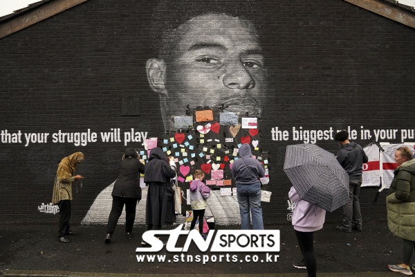 마커스 래시포드의 훼손된 벽화를 롤링 페이퍼로 감싸주고 있는 팬들의 모습. 사진｜뉴시스/AP