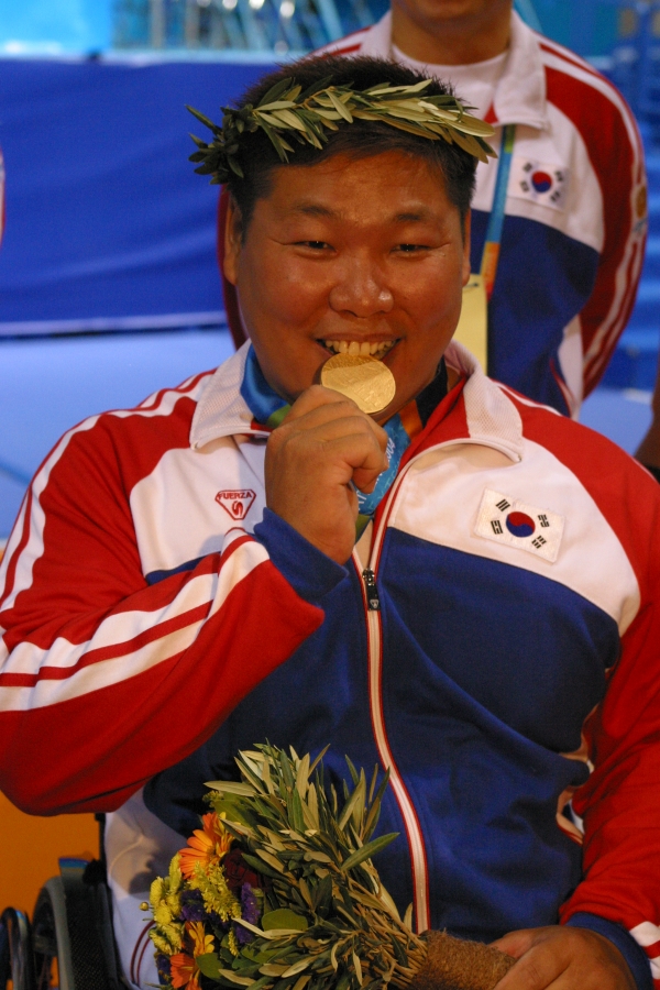박종철 선수촌장이 2004 아테네 패럴림픽대회 역도 메달시상식에서 금메달을 수여받고 기념촬영을 하고 있다. 사진｜대한장애인체육회