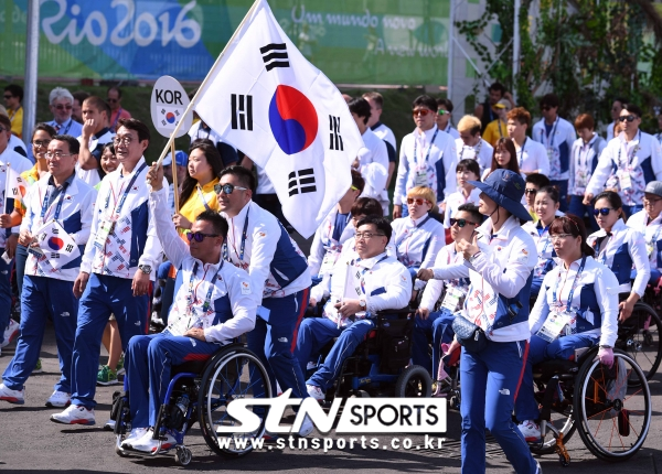브라질 리우데자네이루 선수촌 플라자에서 ‘2016 리우 패럴림픽’ 한국선수단 입촌식에서 기수인 이하걸 선수가 태극기를 휘날리며 입장하고 있는 모습. 사진｜뉴시스